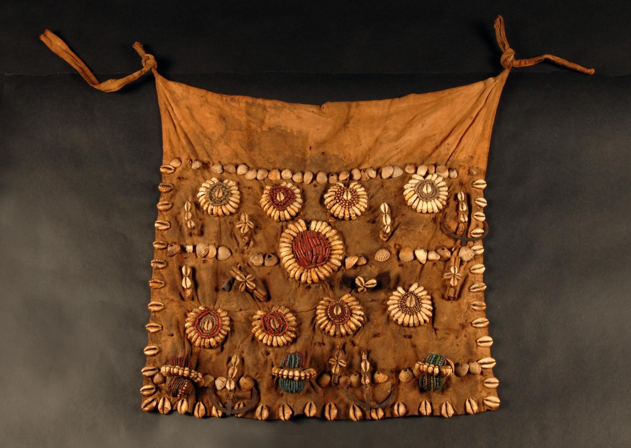 "Pagne" Fon (Bénin), le cartel ancien indique « Tablier d’Amazone du Roi » collecté à l’issue de la bataille d’Atchoupa le 8 mars 1890, don du lieutenant Jean Grand – coll. muséum, MHNT.ATH.AC.559